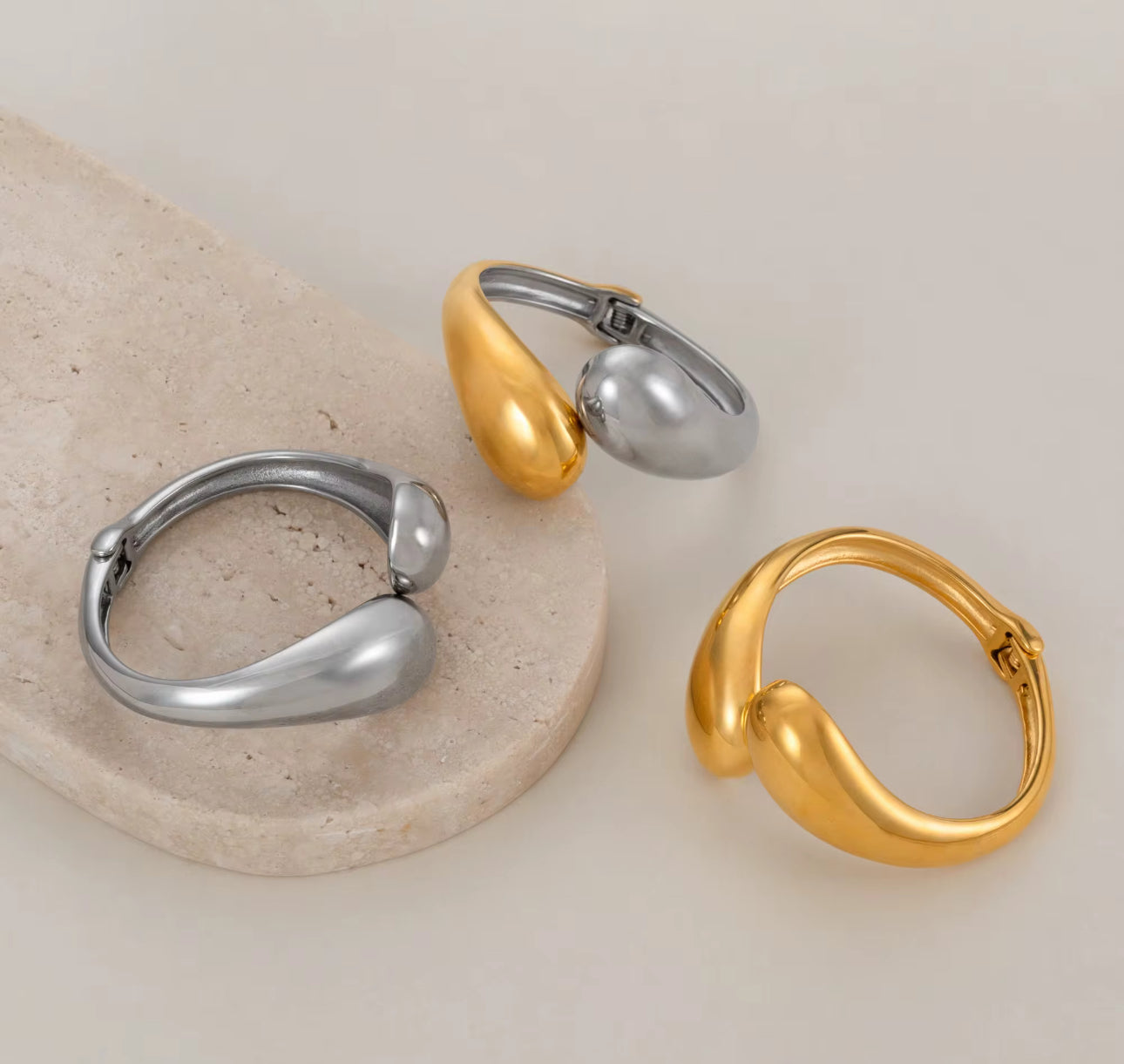 Daisy Bangles in 18k Gold-Plated and Silver Stainless Steel, sculpted drop design, waterproof hypoallergenic jewelry flat lay