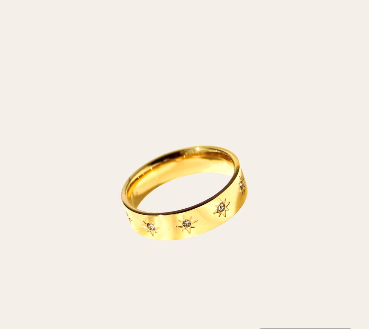 Nova Ring, gold-plated band with starburst-set clear zircon accents on plain background