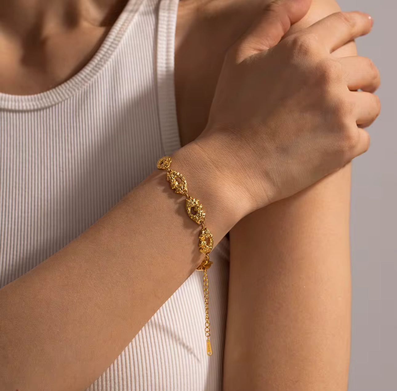 Model wearing the Ripple Bracelet, textured 18k Gold-Plated stainless steel design, waterproof tarnish-free everyday jewelry