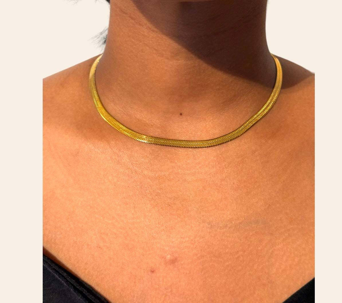 Model wearing Snake Chain necklace in gold variant, close-up on neckline