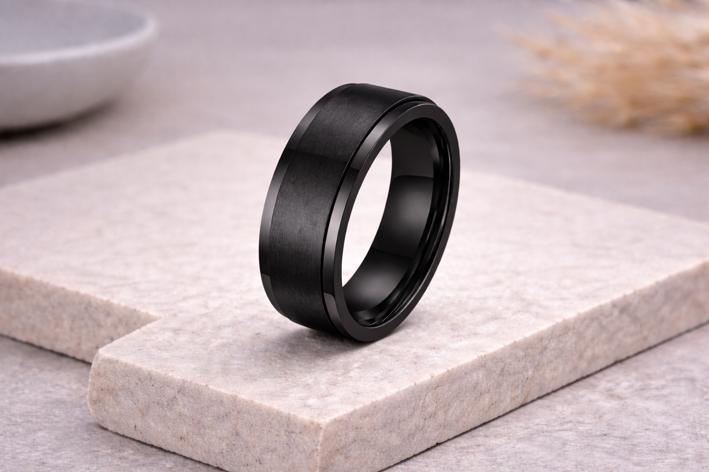 Black ring on a light stone surface with a blurred background