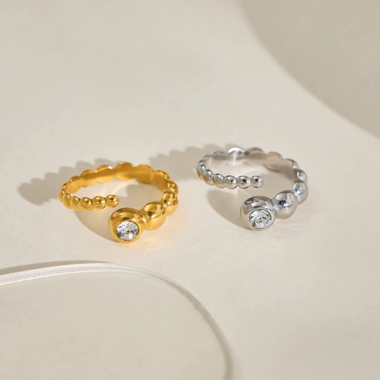 Gold band ring with bezel-set clear zircon stones