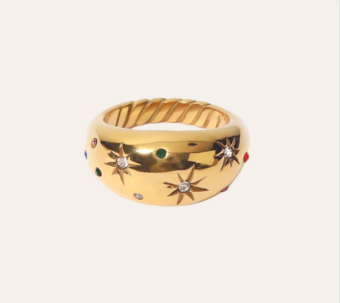 Galaxy Ring—gold-plated dome band with starburst engravings and multicolor zircon on plain background