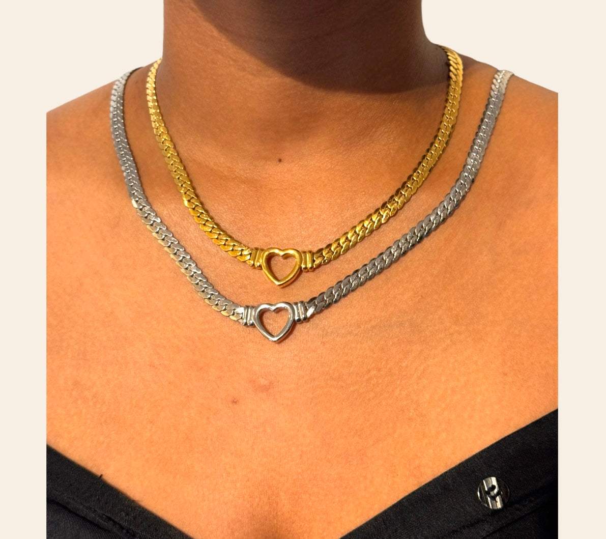 Model wearing two Heart Chain Necklaces gold-plated and stainless steel stacked