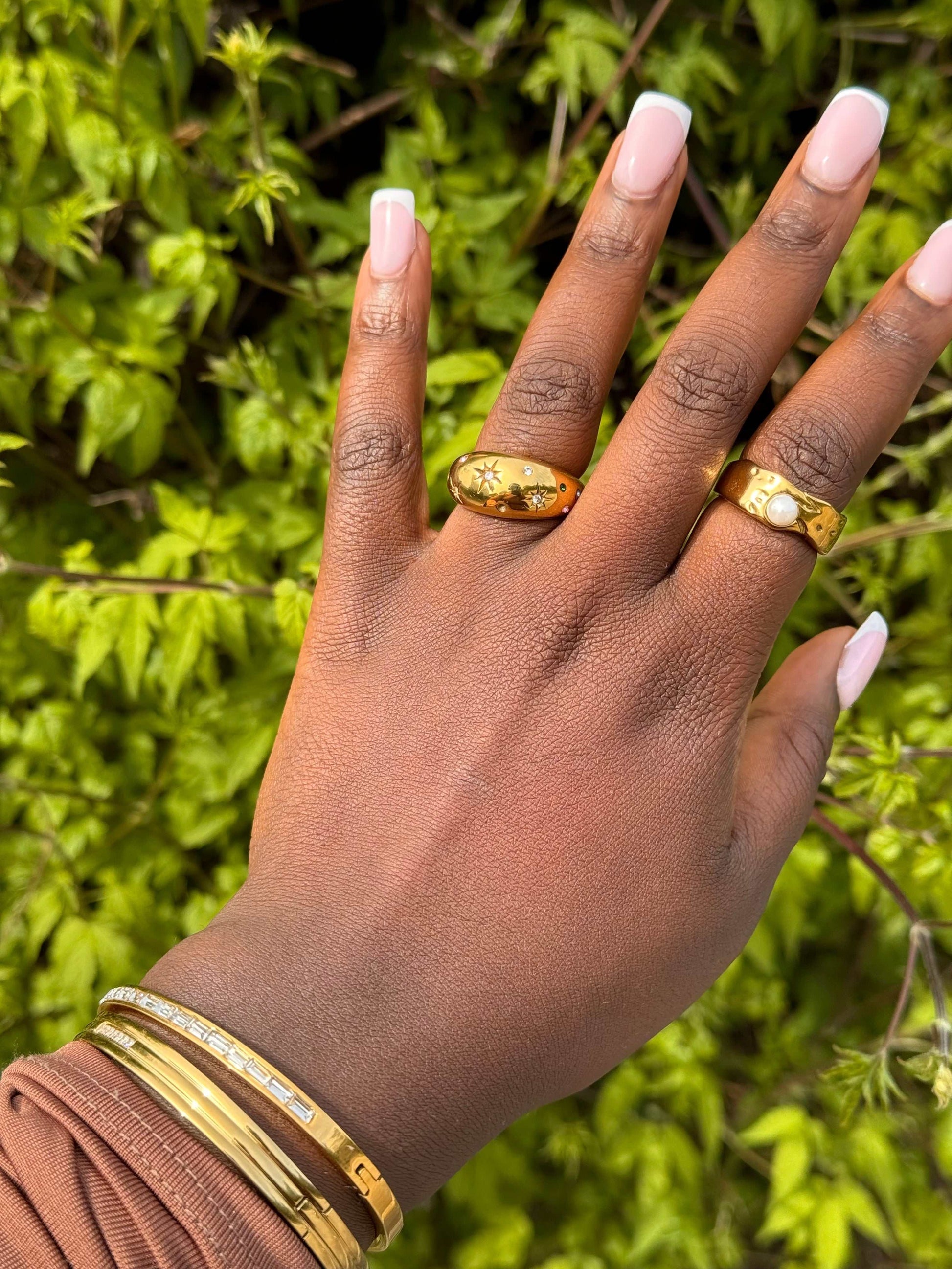 Model close-up wearing the Jolly Ring stacked with other rings in outdoor light