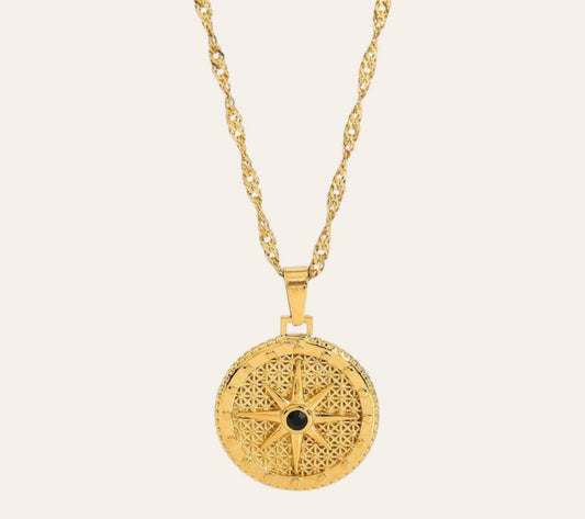 Nova Compass Necklace with compass-rose pendant and black zircon stone on plain background