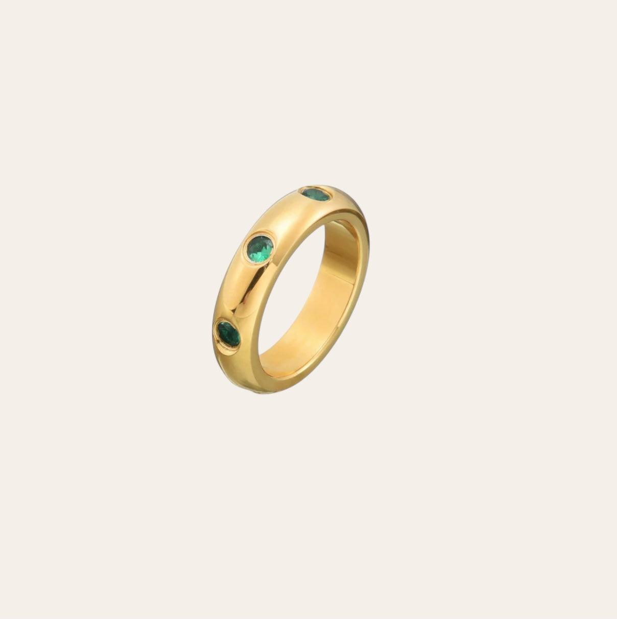 Side view of Olive Ring showing set olive-green zircon stones on plain background
