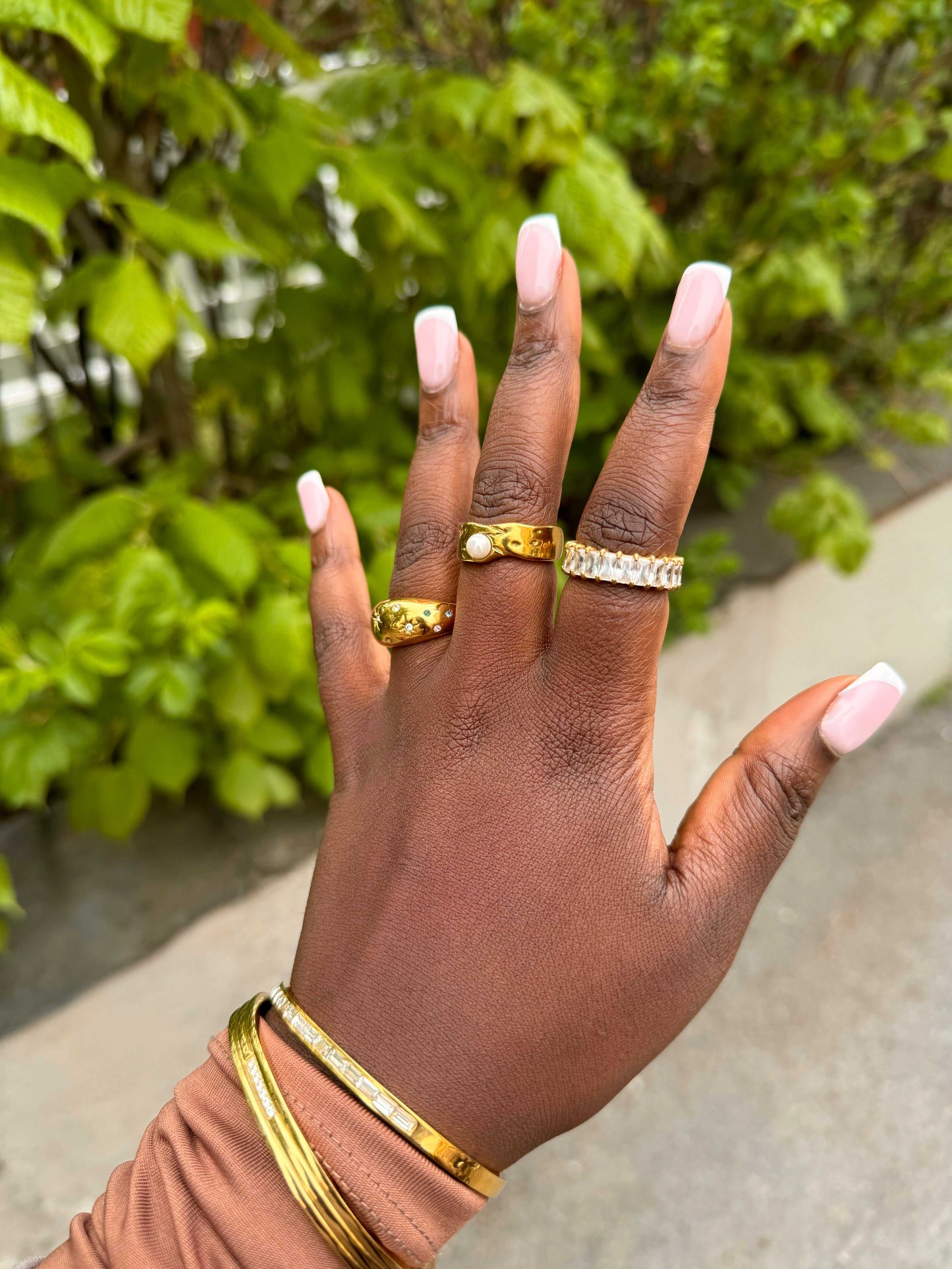 Prism Ring stacked with other gold rings on the model’s hand