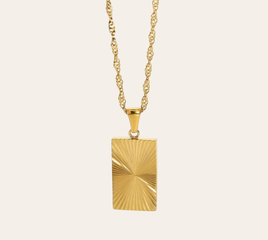 Solar Ray Necklace with sunburst rectangular pendant on plain background