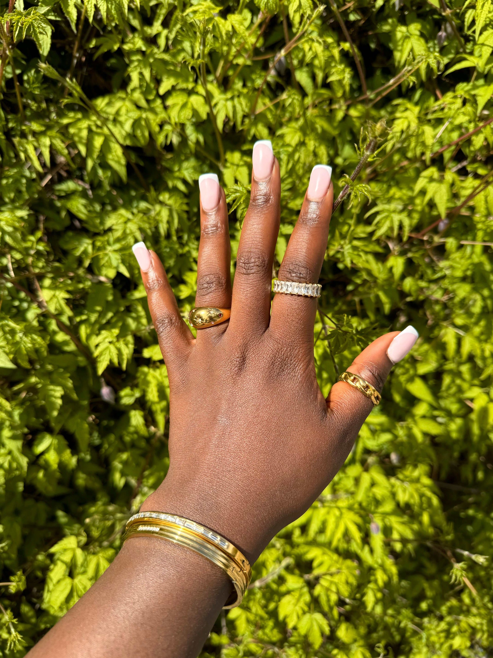 Talia Ring styled in a stacked look on model’s hand, open-link gold-plated band, mid-distance.