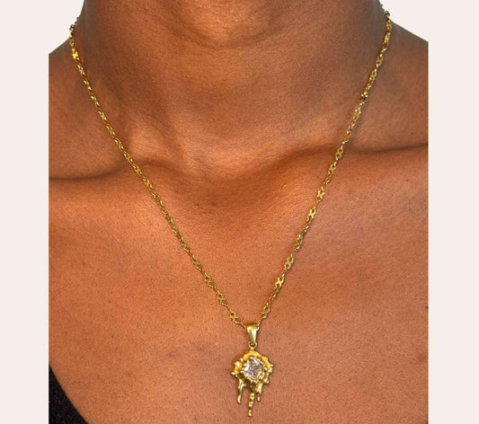 Model wearing Zuri Necklace—molten sun pendant with square-cut zircon, close-up on neckline